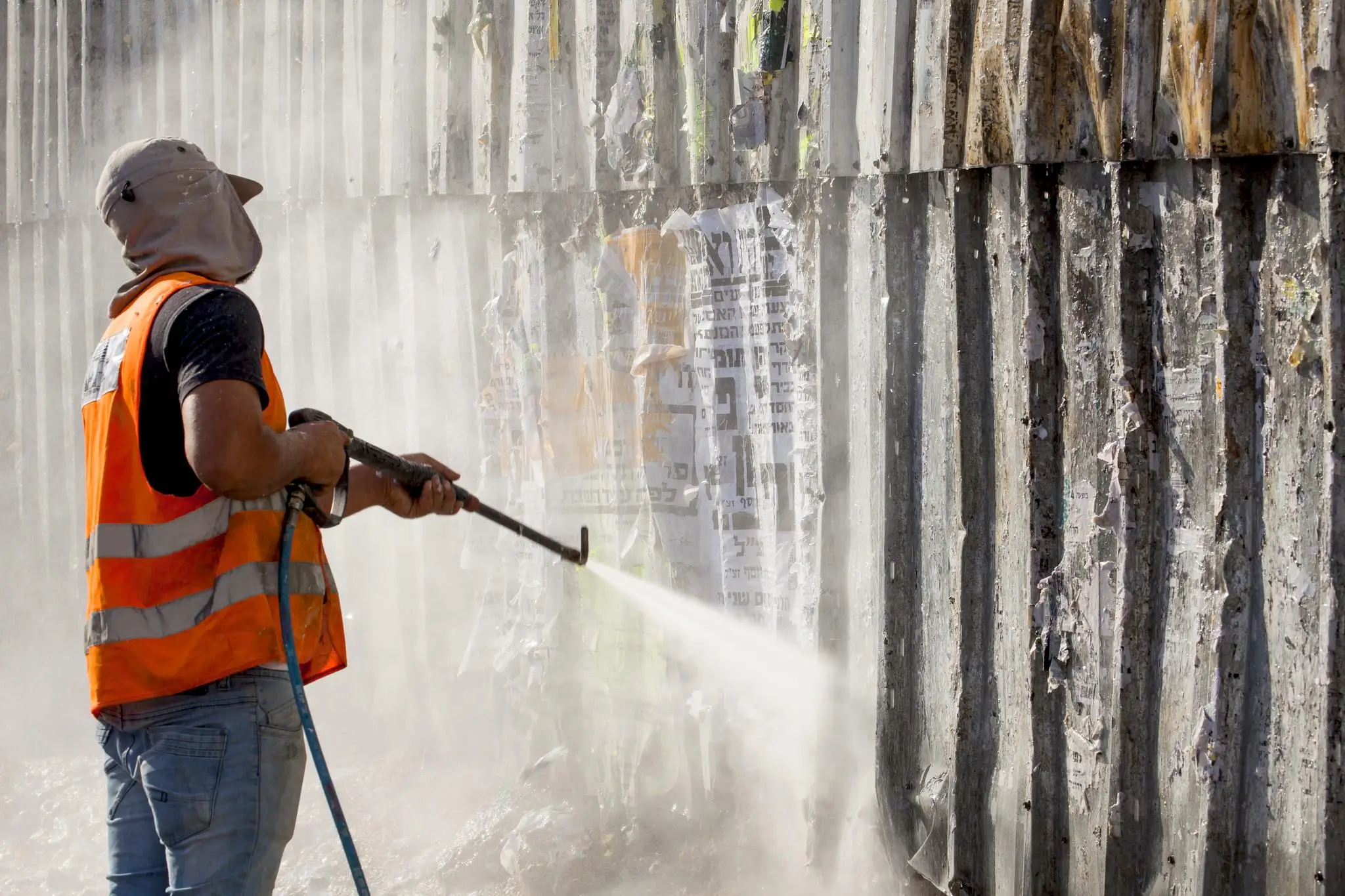 A cleaner using a high-pressure washer, an essential tool for dumpster pad cleaning.