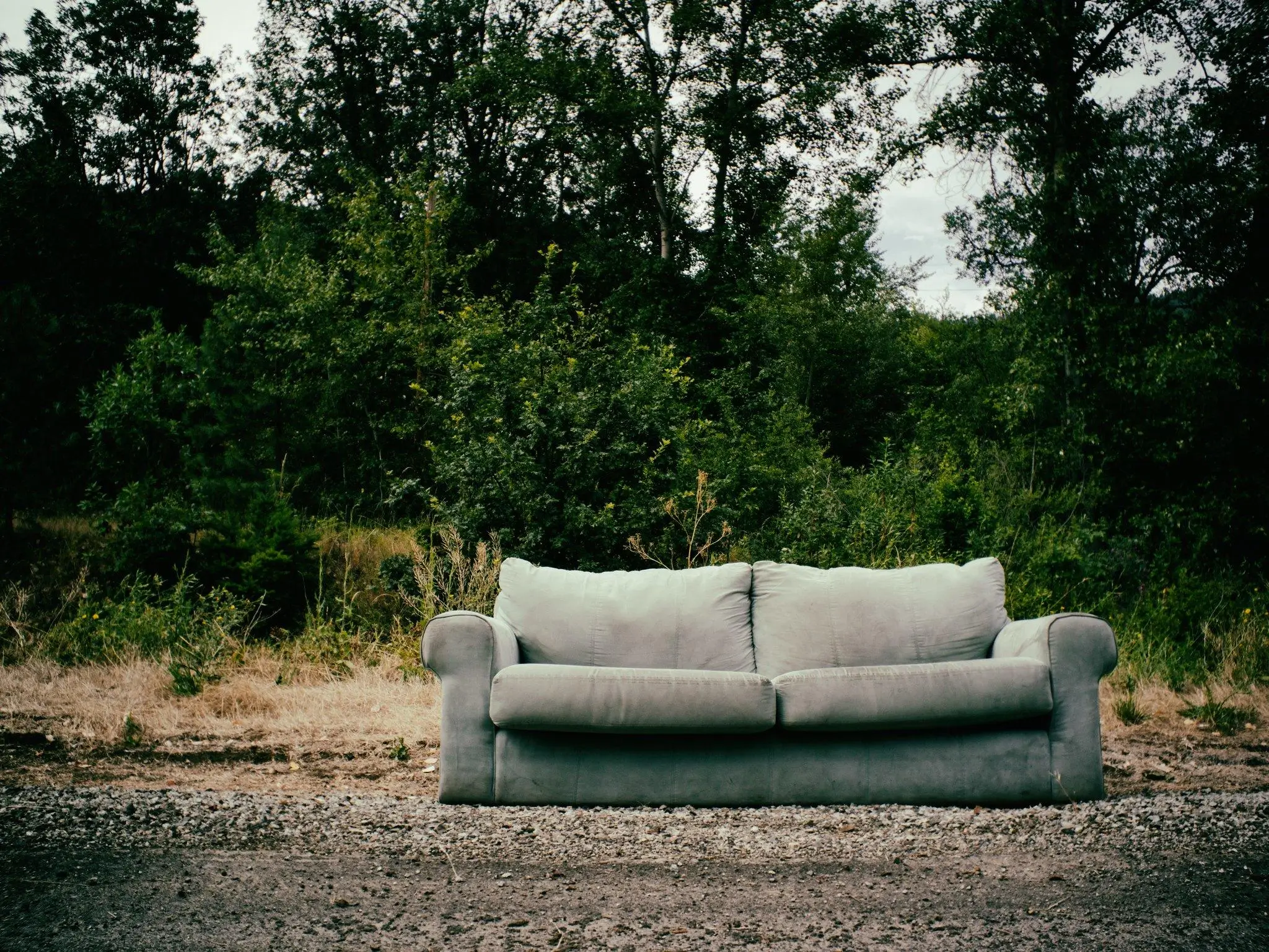 An abandoned old couch, illustrating the kind of bulky junk items that can increase your junk removal costs in Kentucky.