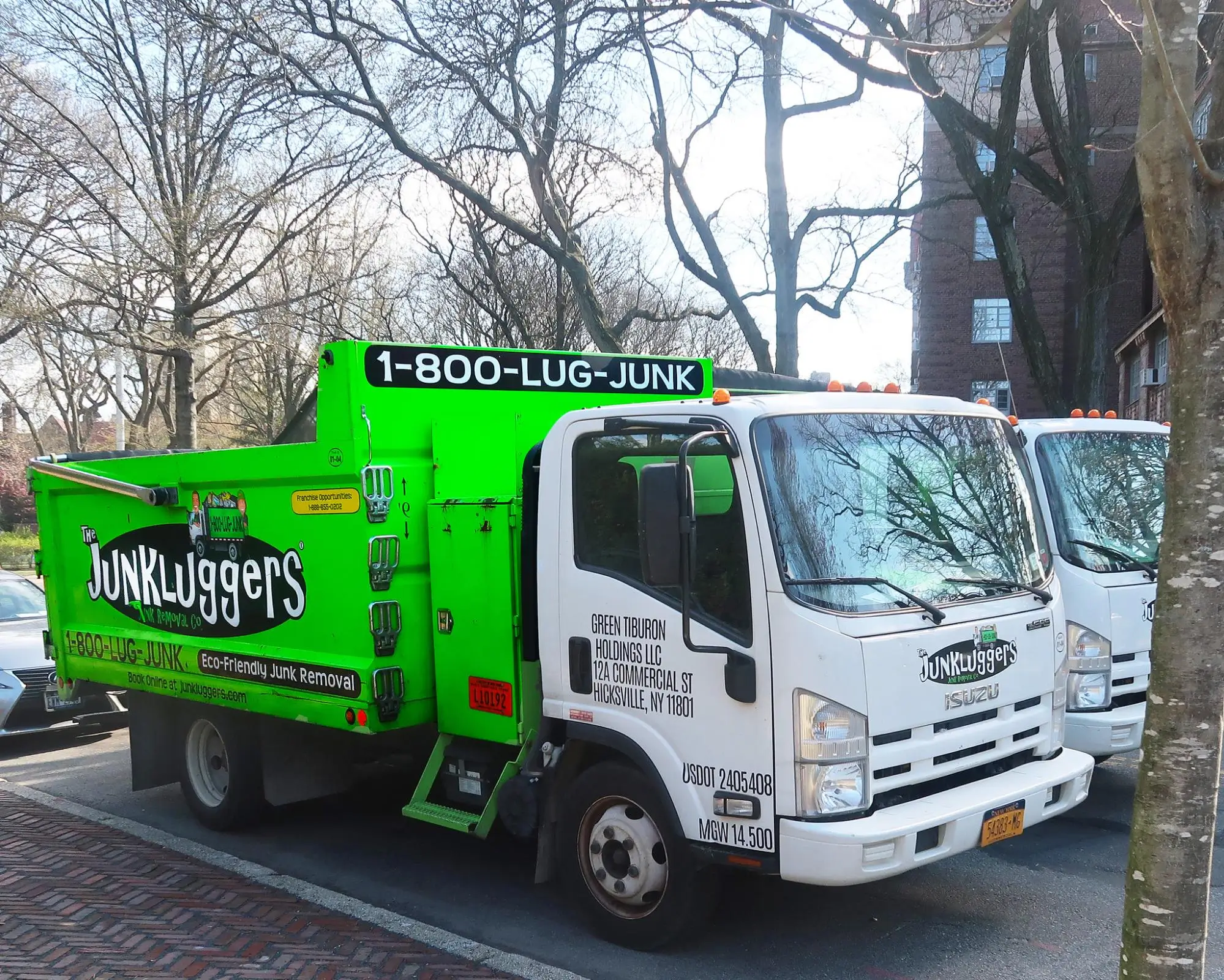 A Junkluggers removal truck, displaying the company's colors and logos.