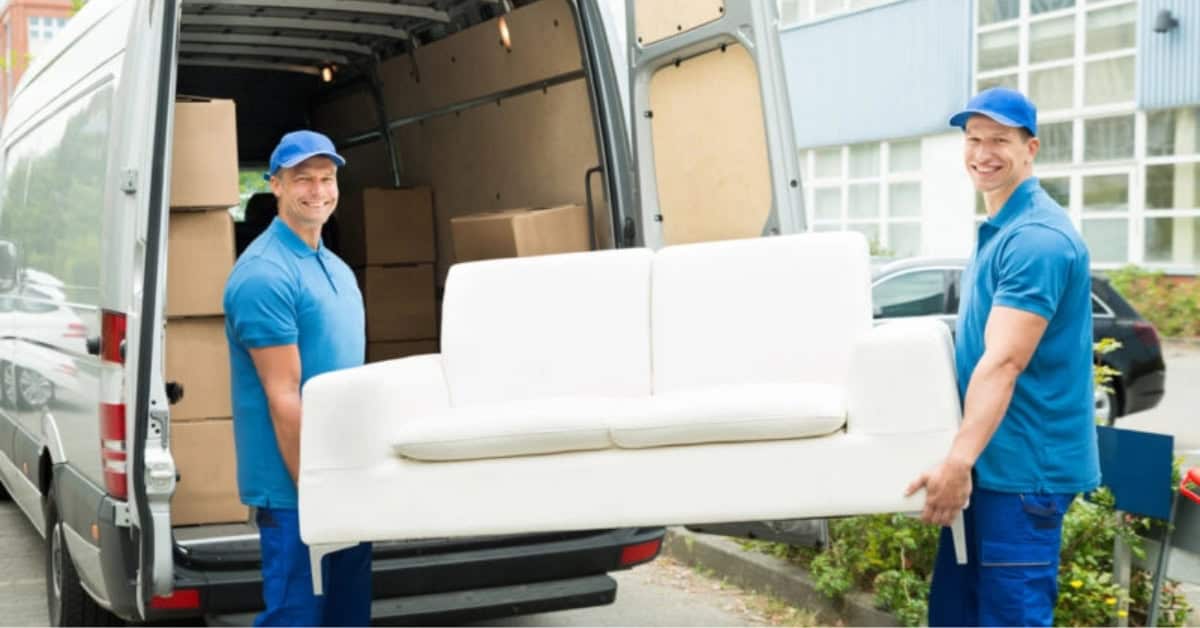 Two movers moving a sofa.